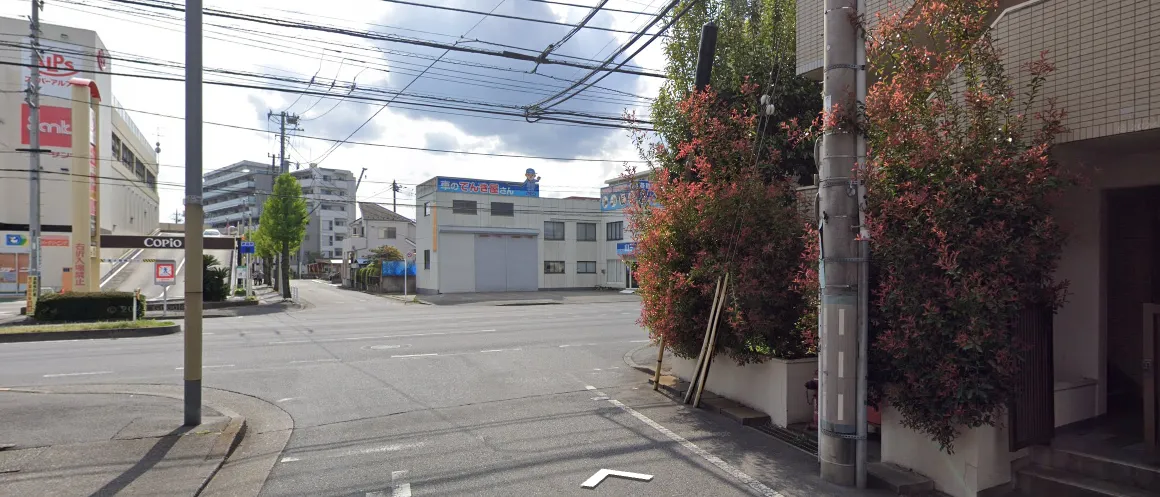 交差点から見たサロン周辺の街並み。左手にスーパーアルプスとCopioの看板