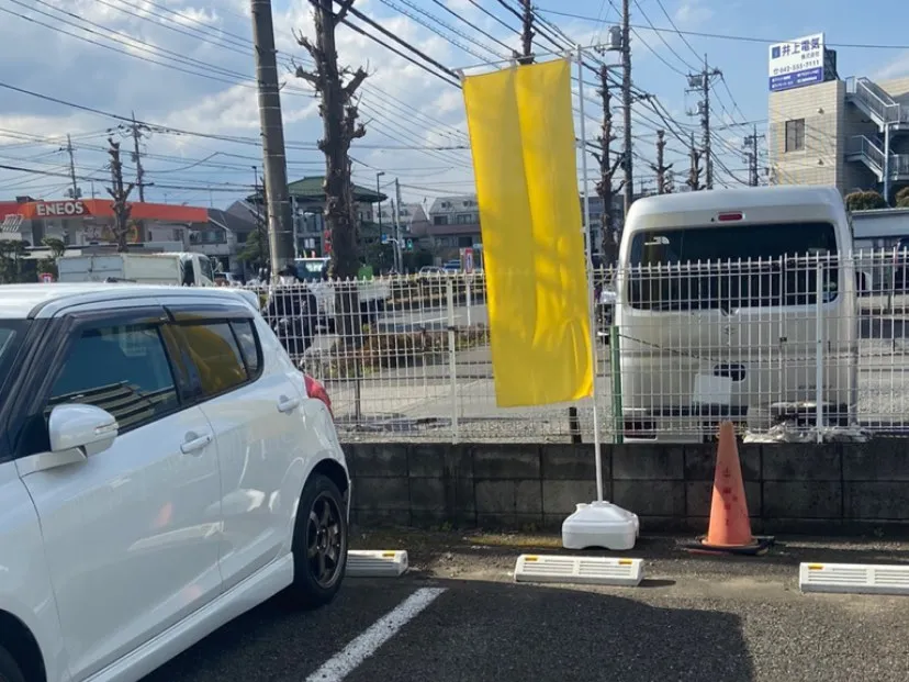 白線で区切られた駐車区画と、目印の黄色いのぼり旗